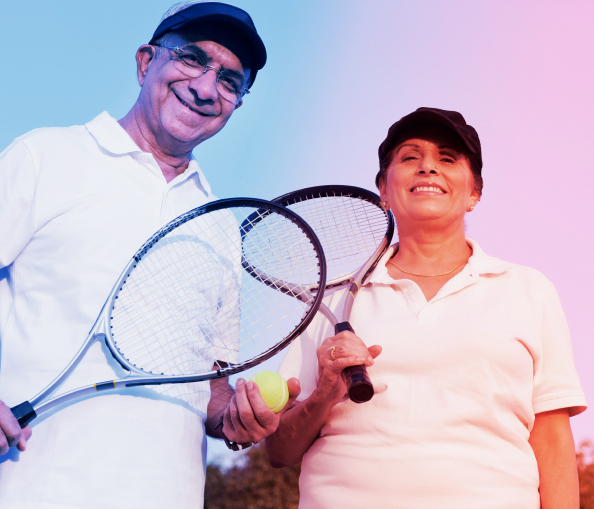 Smiling couple holding tennis raquets